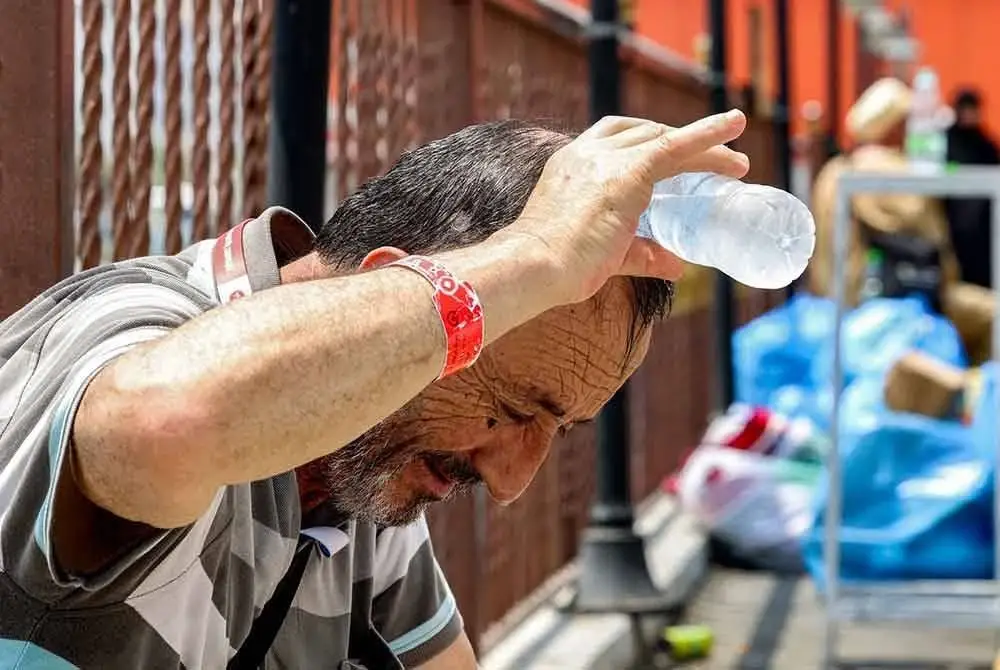 Seorang bakal jemaah haji dari Turkiye menuang air sejuk di atas kepalanya untuk menyejukkan tubuhnya berikutan cuaca terik.