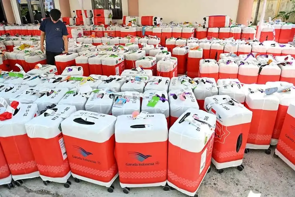 Seorang pekerja memeriksa bagasi bakal jemaah haji dari Indonesia.