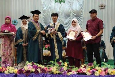 Ahmad Maslan (tiga kiri ) menyampaikan sijil penghargaan kepada pelajar cemerlang peperiksaan SPM di SMK Ayer Baloi di Pontian pada Ahad.