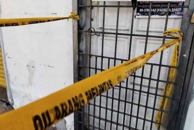 Polis memasang pita keselamatan di lokasi simbah asid di sebuah spa di Beris Kubur Besar, Tawang Bachok.