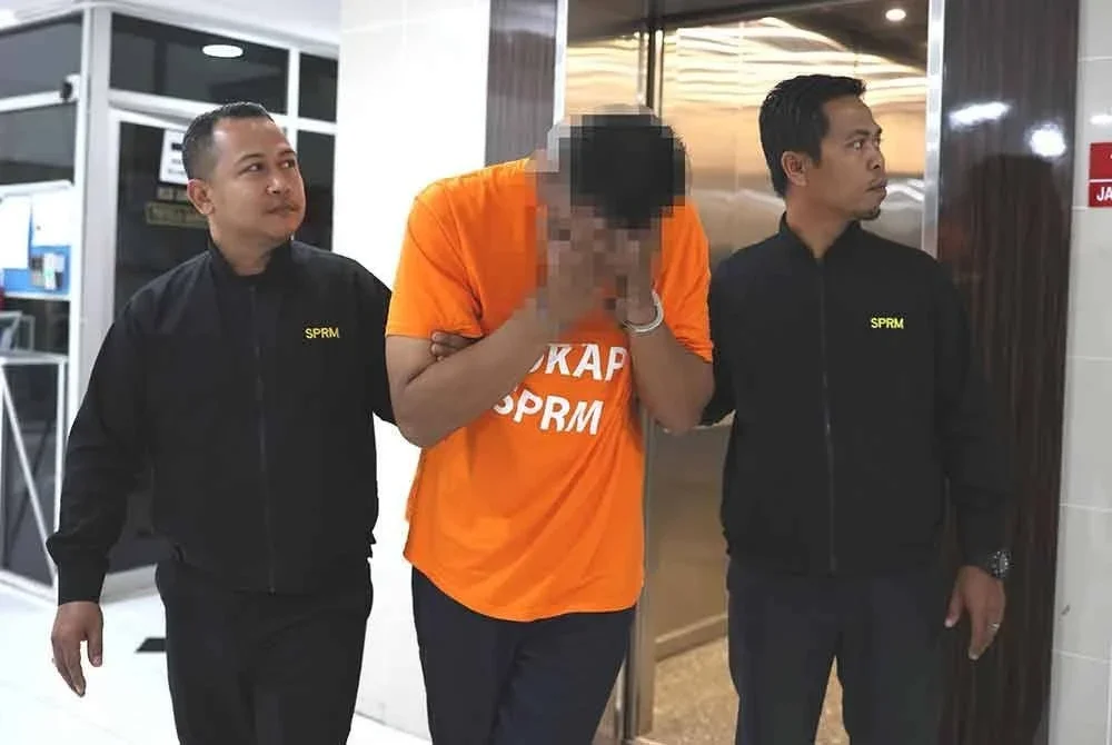 Suspek (tengah) dibawa ke Mahkamah Majistret Kuala Terengganu bagi permohonan reman.