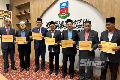 Kamaruzaman (empat dari kiri) dan pentadbir di YIK menunjukkan keputusan STAM bagi tahun 2024. - FOTO: SINAR HARIAN/ADILA SHARINNI WAHID