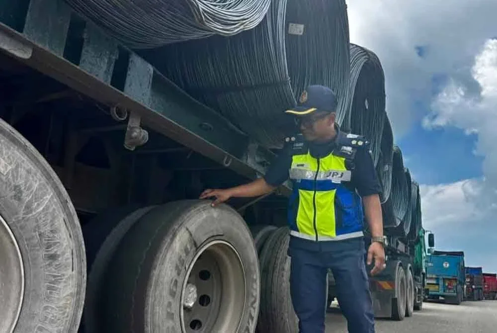 Anggota penguat kuasa JPJ Pahang melakukan pemeriksaan ke atas treler membawa muatan gelung besi yang berhenti di bahu jalan dipercayai cuba mengelak pemeriksaan dalam operasi khas di sekitar Gebeng pada Selasa. Foto FB JPJ PAHANG