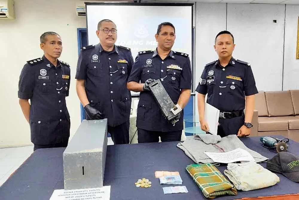 Muhamad Mustafah (dua dari kanan) menunjukkan barang rampasan kes pecah tabung masjid di Kuala Pilah.