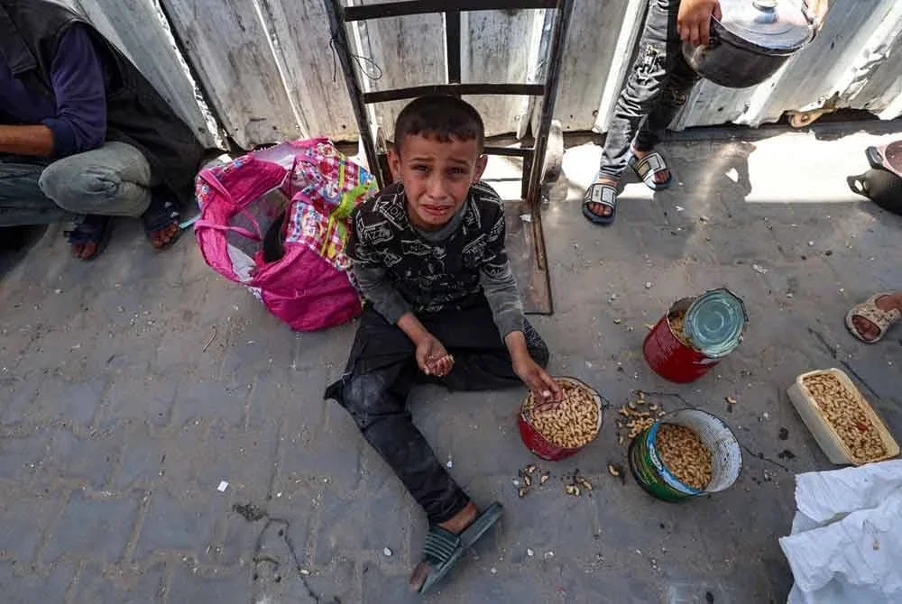 Seorang kanak-kanak Palestin menangis selepas menerima makanan panas diagihkan di kem pelarian Nuseirat di tengah Genting Gaza.