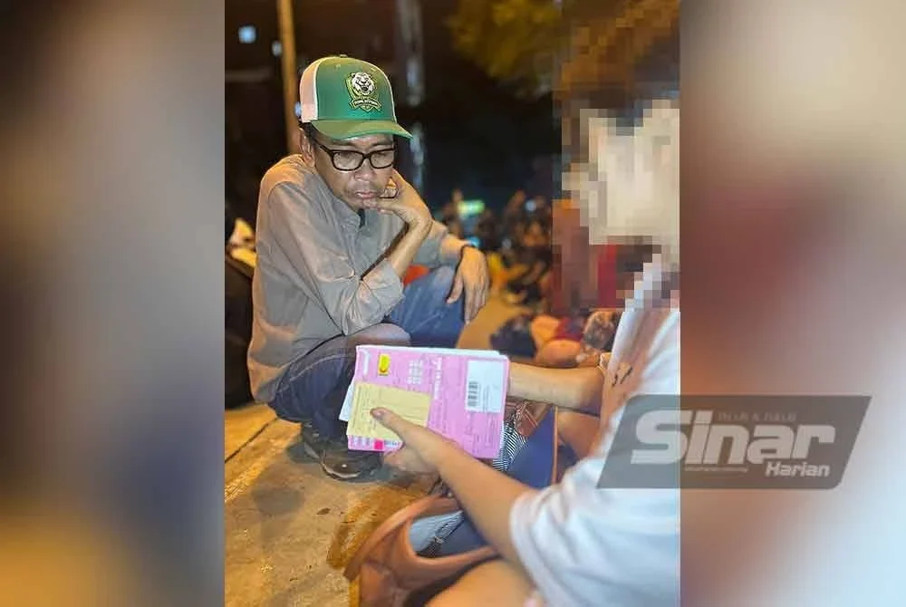 Jefri memeriksa dokumen salah seorang warga asing yang ditahan dalam Ops Mega di sebuah apartment di Bandar Sunway pada Khamis.