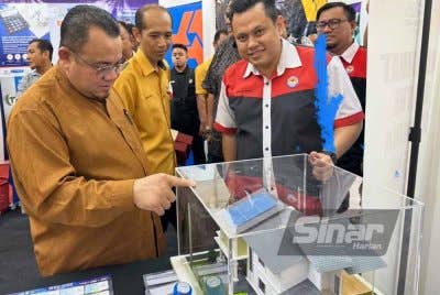 Hilmi (kiri) diiringi Hasniro (tengah) melihat replika rumah dibina dengan dilengkapi panel solar. FOTO SINAR HARIAN-ADILA SHARINNI WAHID