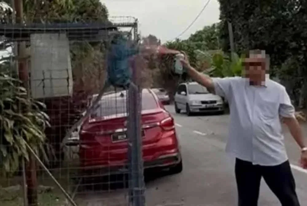 Tangkap layar video tular seorang lelaki menyembur badan monyet dengan cat.