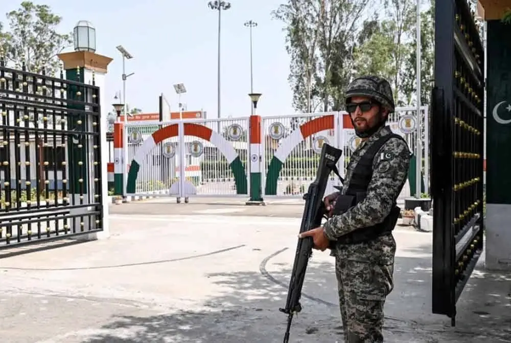 Seorang anggota pengawal Pakistan bertugas di Kompleks Koridor Kartarpur Sahib yang terletak di sepanjang sempadan India-Pakistan di Kartarpur pada 22 Mei. -AFP
