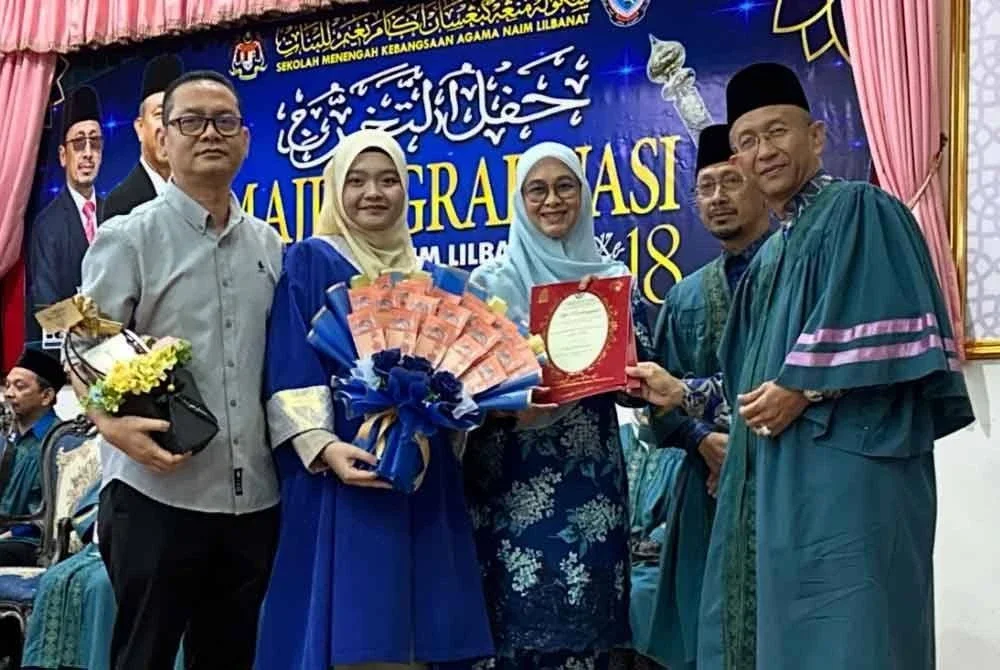 Tuan Nur Hannah (dua dari kiri) bersama ibu bapanya menerima anugerah yang disampaikan oleh Mohd Fauzan (kanan) sambil diiringi Ab Raisham (dua dari kanan).