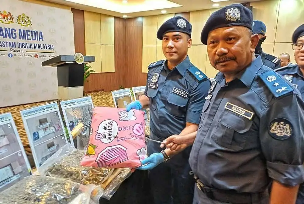 Mohd Asri menunjukkan sarung bantal yang digunakan untuk mengisi bunga ganja bagi mengaburi mata pihak berkuasa pada sidang akhbar di Wisma Kastam Sultan Ahmad Shah, Indera Mahkota pada Isnin. - FOTO SINAR HARIAN