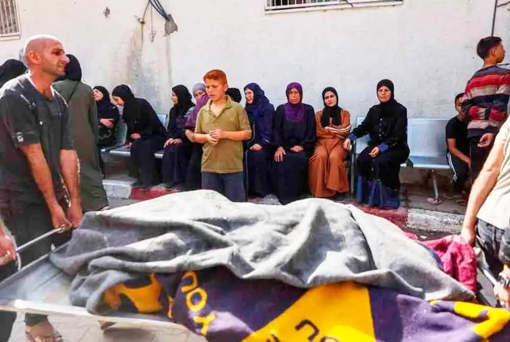 Orang ramai mengusung jenazah mangsa serangan udara Israel di Hospital Al-Shifa, Gaza City. Foto AFP