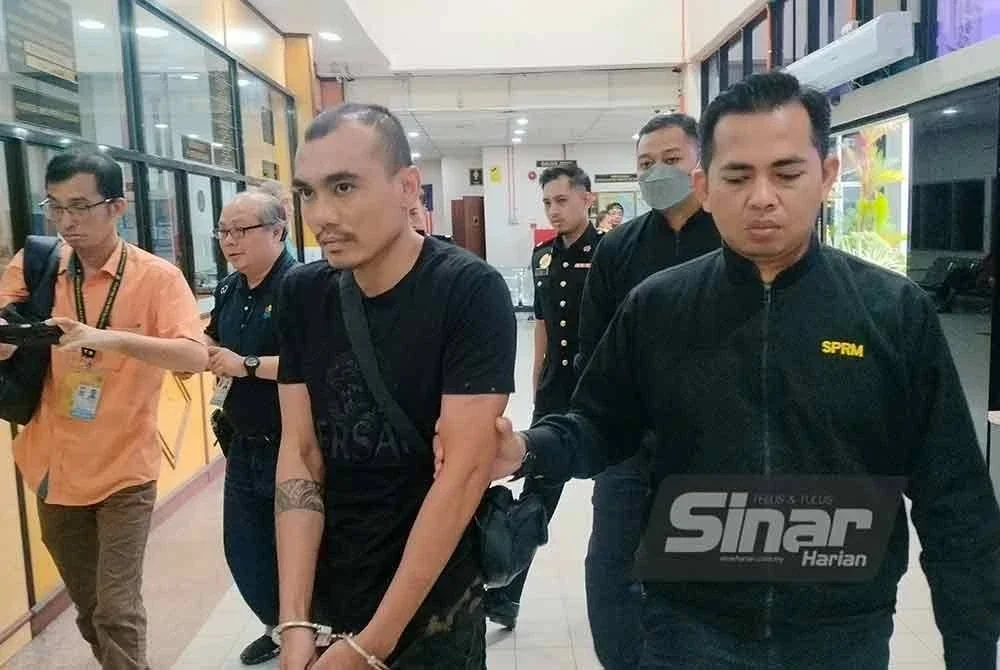 Tertuduh diiringi pegawai SPRM ketika dibawa ke Mahkamah Butterworth pada Selasa.