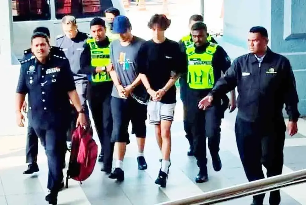 Ye Yingxi berbaju hitam (dua dari kanan) dan Zhang Runbao bertopi biru (empat dari kiri) dibawa ke Mahkamah Sesyen Kuala Lumpur. Gambar fail