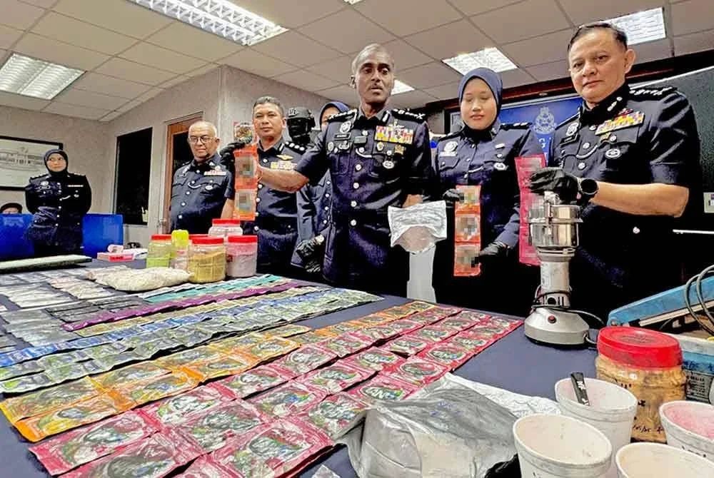 Kumar (tengah) menunjukkan bungkusan dadah yang dirampas dalam serbuan berkenaan.