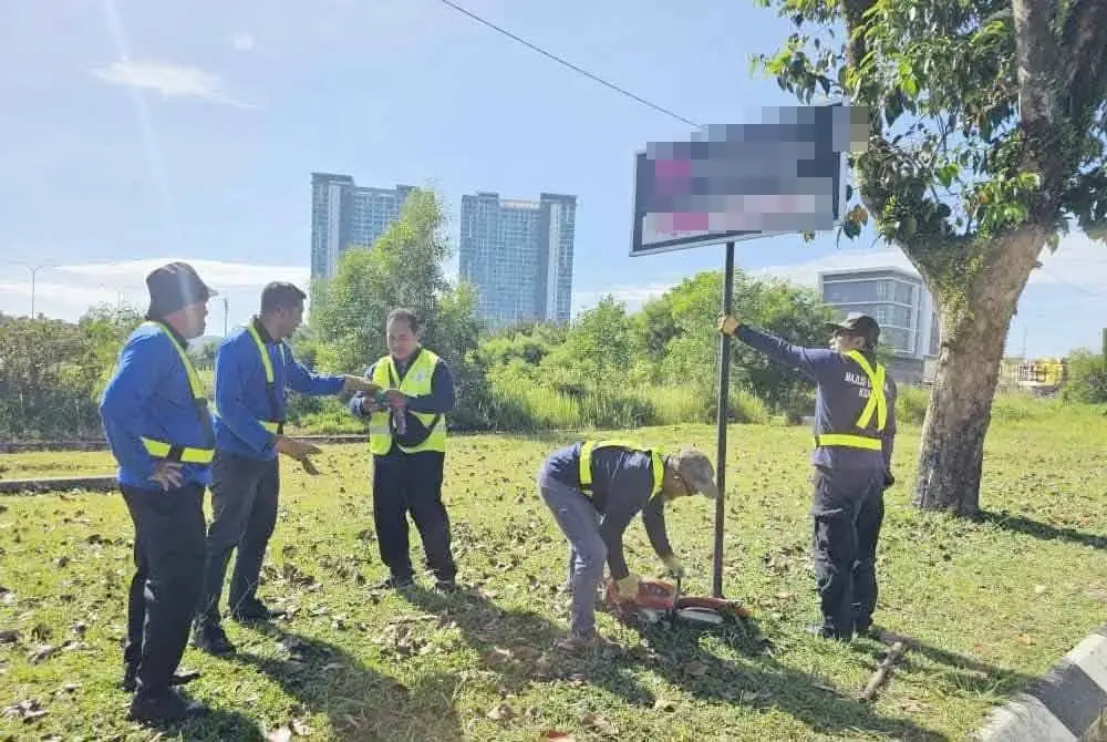 Pasukan penguat kuasa MBK mencabut papan tanda yang dipasang tanpa kebenaran di sekitar Kuantan. Foto: Facebook MBK