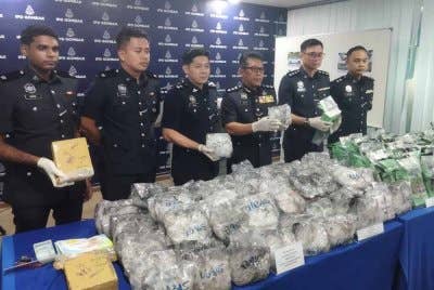 Noor Ariffin (tiga dari kanan) menunjukkan bungkusan dadah dianggar bernilai lebih RM7 juta yang dirampas susulan tangkapan ke atas tiga individu termasuk sepasang kekasih di Gombak.