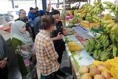 Mohd Zuhairi menerangkan kepada salah seorang peniaga berkaitan peraturan tanda harga pada pemeriksaan mengejut KPDN Selangor di sebuah pasar di Kuala Langat pada Khamis.