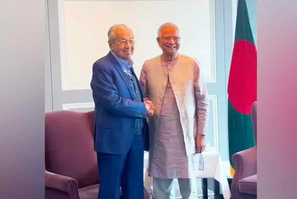 Tun Dr Mahathir (kiri) bersalaman dengan Muhammad Yunus dalam satu sesi pertemuan baru-baru ini.