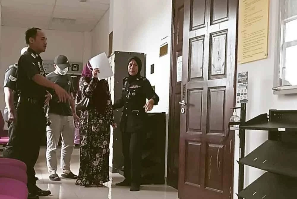 Kedua-dua tertuduh ketika keluar dari Mahkamah Tinggi Syariah atas pertuduhan percubaan melakukan zina.