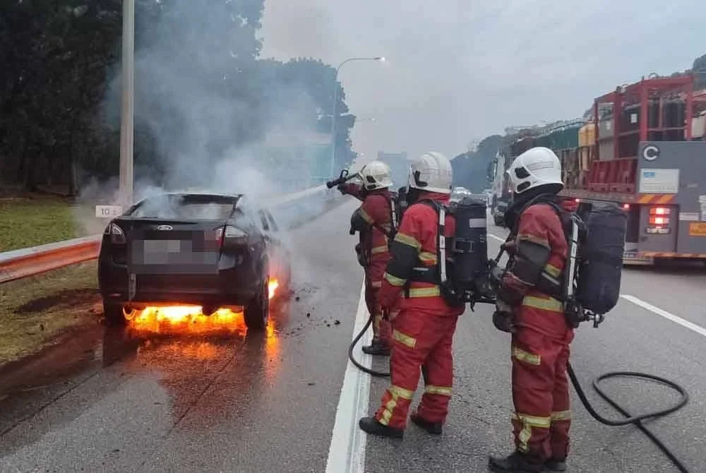 Anggota bomba sedang memadamkan sebuah kereta terbakar di kilometer 10.5 Lebuhraya Utara Selatan Hubungan Tengah (ELITE) Putra Height menghala ke USJ pada Sabtu.