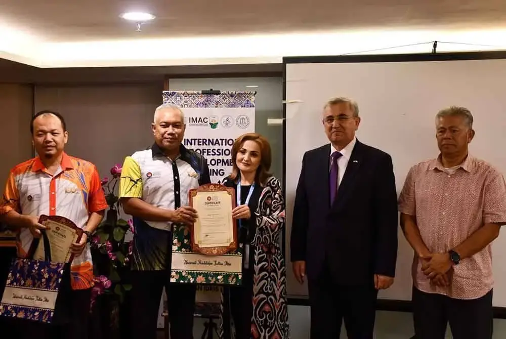 Dr Md Amin (dua dari kiri) bersama Karomidin (dua dari kanan) menyampaikan sijil tamat latihan kepada seorang peserta program.