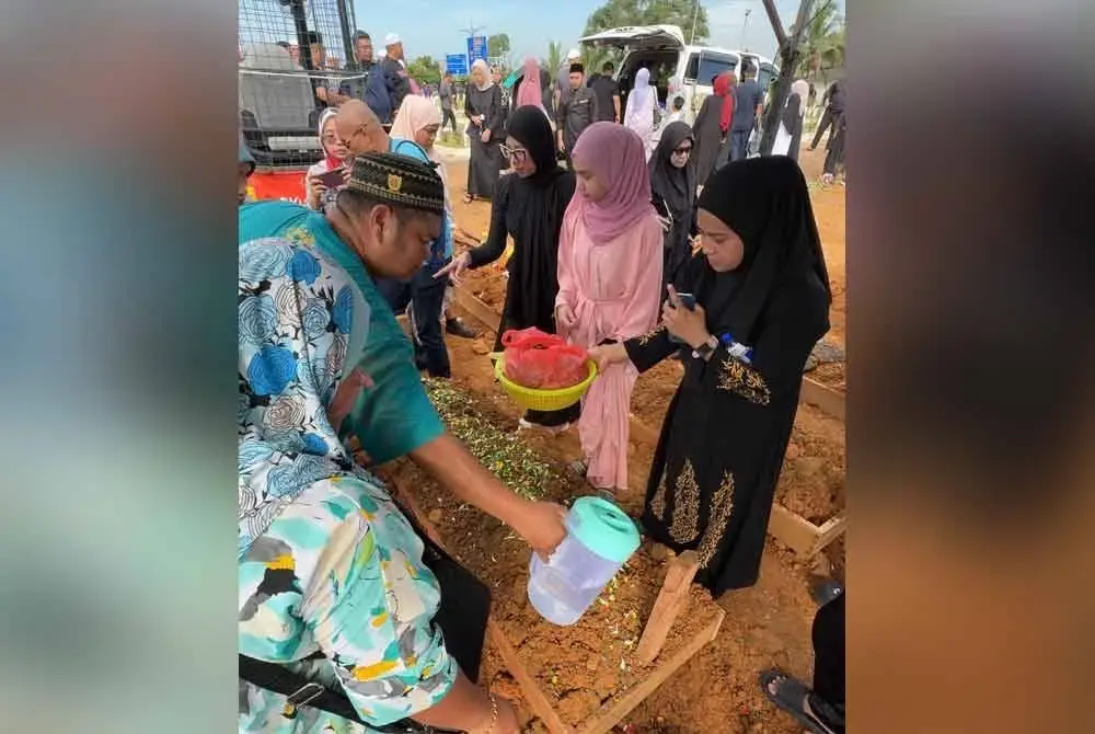 Keluarga Nur Atikah Najihah menabur daun pandan di pusara arwah selepas bacaan talkin.