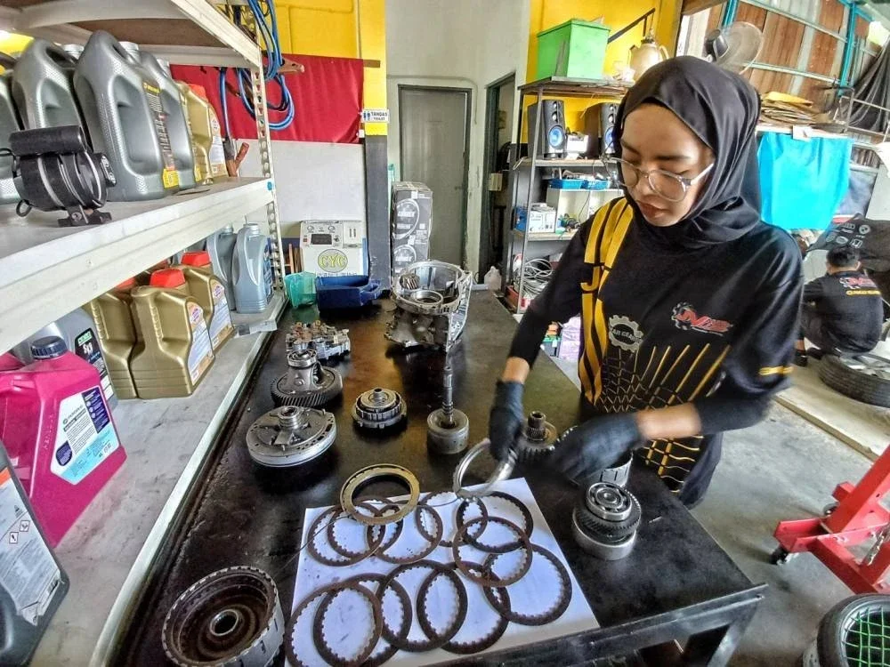 Sofia Nabila menunjukkan komponen enjin yang akan dipasang untuk kerja-kerja baik pulih enjin.