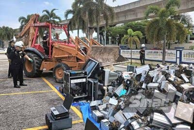 Mohd Zaini (menaiki jentolak) melakukan gimik pelupusan barangan rampasan di Ibu Pejabat Polis Daerah (IPD) Subang Jaya pada Selasa. Foto: HISYAMUDDIN AYUB.