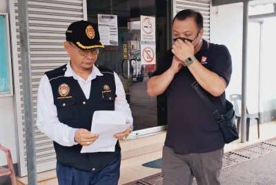 Wei Lian (kanan) ketika dihadapkan ke Mahkamah Majistret Kemaman pada Selasa atas kesalahan menjual rokok di bawah harga jualan minimum.