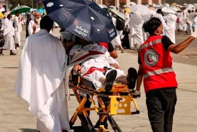 Anggota pasukan perubatan membantu seorang jemaah yang terjejas akibat panas terik di kaki Bukit Arafah semasa ibadah haji tahunan pada tahun lalu. Foto AFP