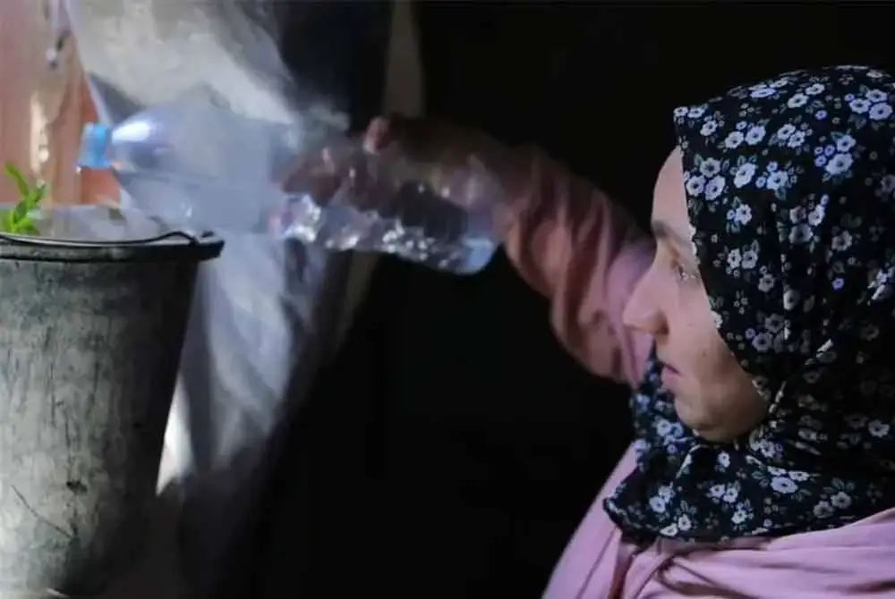 Aseel menyiram sepohon pokok kecil di dalam khemah sempit keluarganya di utara Gaza. Foto Noor Al-Halabi/Al Jazeera