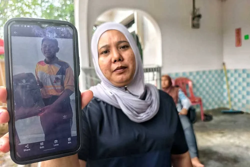 Norehan menunjukkan gambar anak keduanya, Muhamad Aidil Asyraf yang masih belum ditemui.