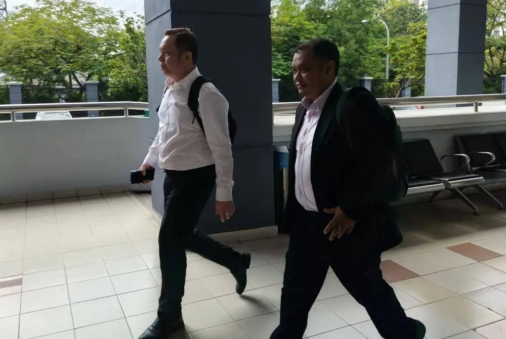 Wei Choong (kiri) mengaku tidak bersalah selepas semua pertuduhan dibacakan ke atasnya di hadapan Hakim Mohamad Kamil Nizam.