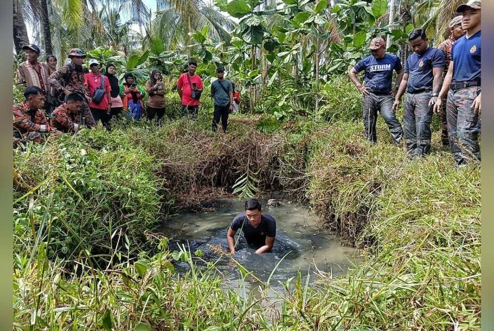 Anggota bomba mengendalikan pam sedut air bagi mengeluarkan air dari kolam terbiar.
