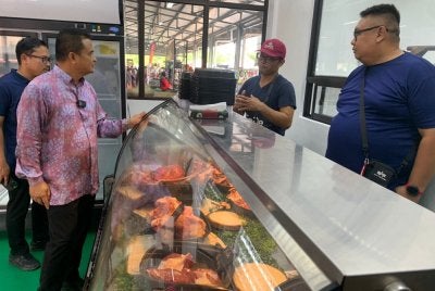 Zahari (dua dari kiri) meninjau barangan keperluan harian sempena Aidiladha di Pasar Tani Kekal Jalan Datin Halimah Johor Bahru pada Khamis.