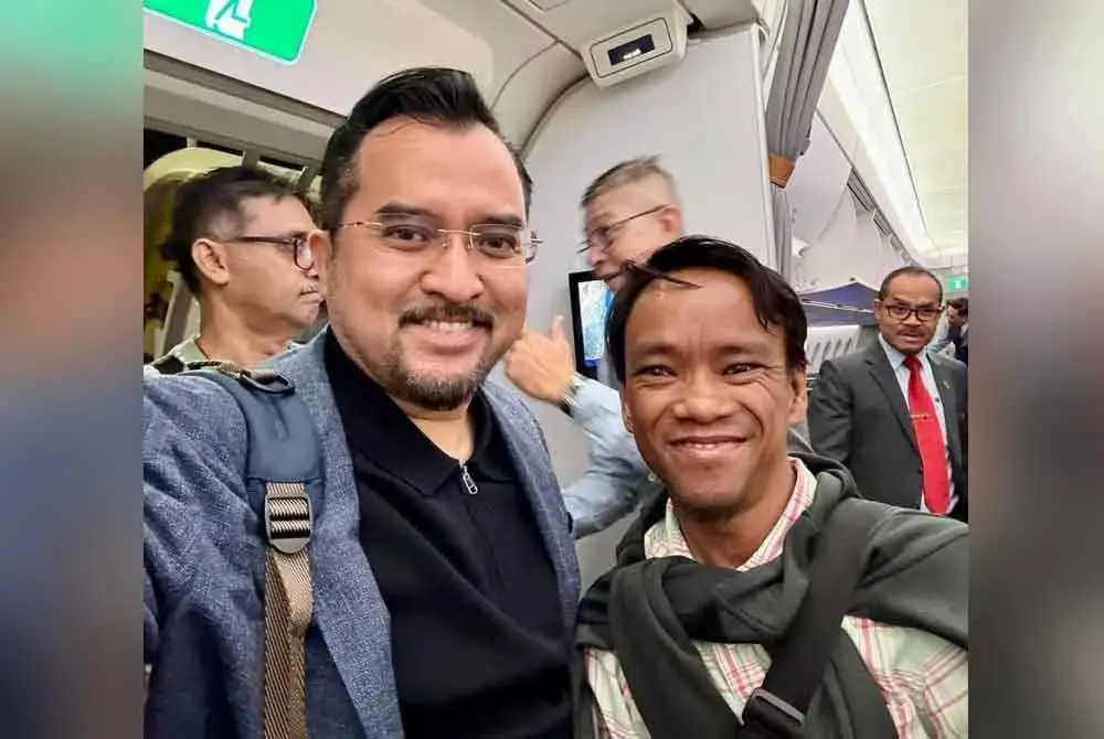 Asyraf Wajdi bergambar bersama Ibrahim ketika berjumpa dalam penerbangan pulang dari Doha ke Kuala Lumpur.