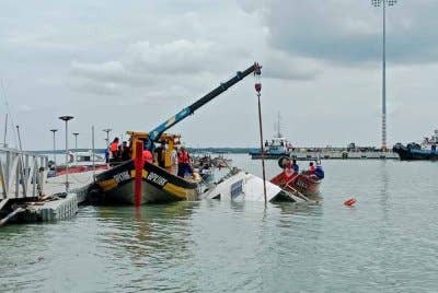Operasi menaikkan bot yang terbalik di perairan Tanjung Harapan sedang dijalankan pada Sabtu.