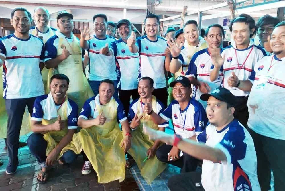 Mohd Hairi (berdiri, lima dari kanan) bersama petugas Majlis Korban Perdana di Surau Jumaat, Taman Skudai Kanan, pada Ahad.