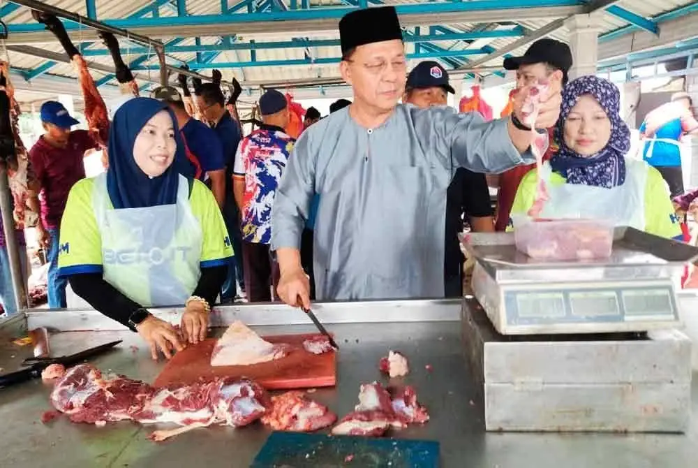 Hasni (tengah) pada program korban DUN Benut di Kampung Permatang Palas, Benut pada Ahad.