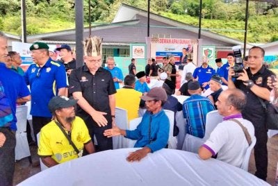 Adly (kiri) bertemu penduduk Kampung Sungai Rual ketika Lawatan Kerja dan Korban Sempena Hari Raya Aidiladha Bersama Anggota Operasi Merpati Negeri Kelantan di Jeli pada Ahad.