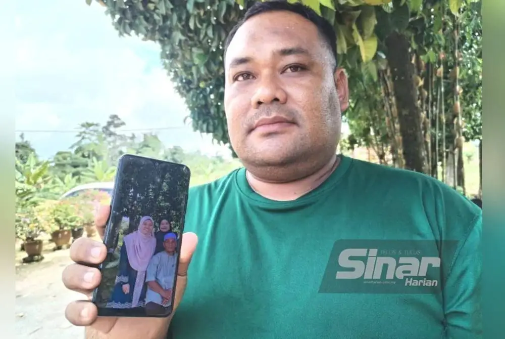 Mohd Farid Firdaus menunjukkan gambar arwah adiknya ketika ditemui pemberita di Kampung Gong Pasir Besut pada Isnin.