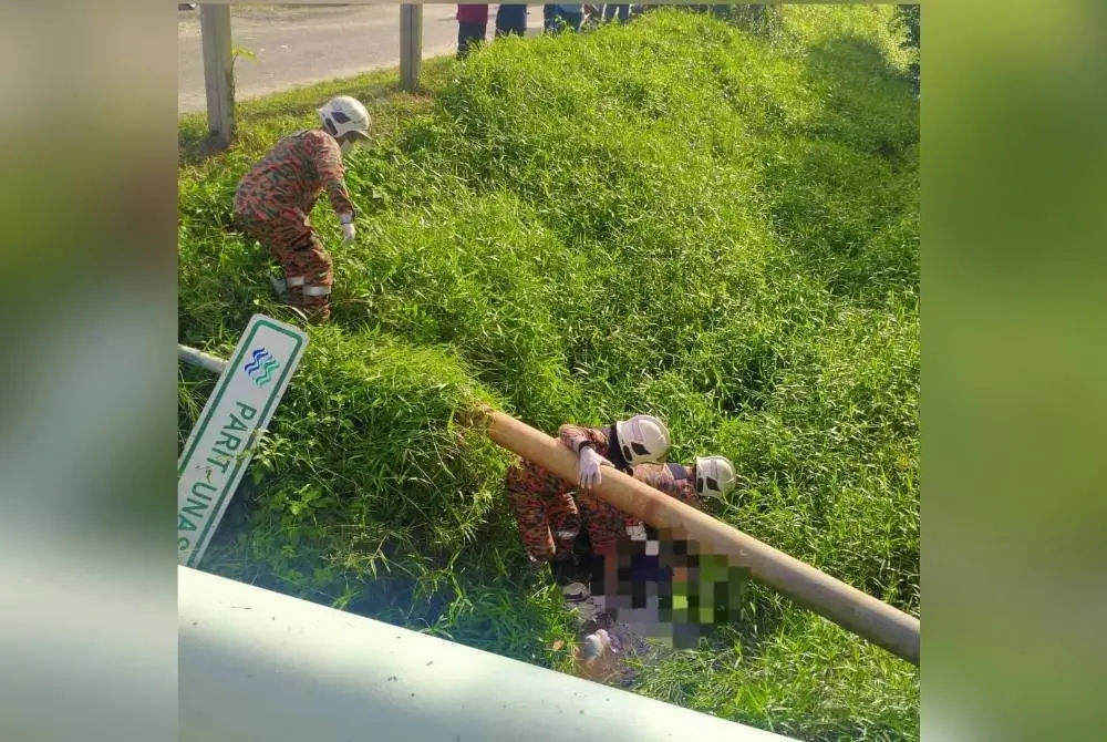 Anggoa bomba berusaha mengeluarkan mangsa yang tercampak ke dalam parit berhampiran.