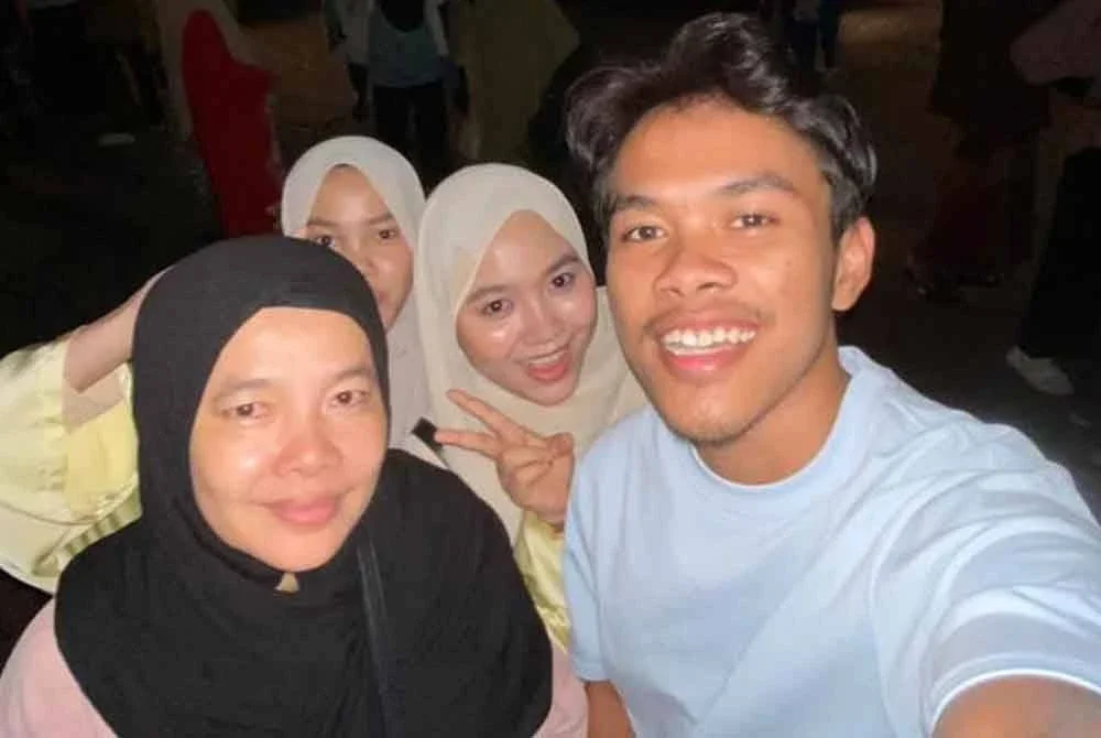 Fakhrul Arif (kanan) merakam gambar bersama ibunya (kiri) serta dua lagi adik beradiknya sebelum menaiki bas bertolak ke UPSI pada Isnin.