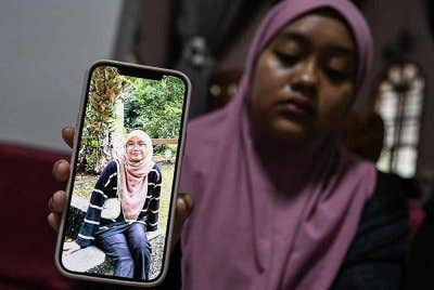 Kakak mangsa, Nur Ainul Afiqah, 22, menunjukkan gambar adiknya Allahyarhamah Nur Ainul Qistina, 21, yang terlibat dalam kemalangan bas di Jalan Raya Timur-Barat (JRTB) berhampiran Tasik Banding, Gerik, awal pagi Isnin. Foto Bernama