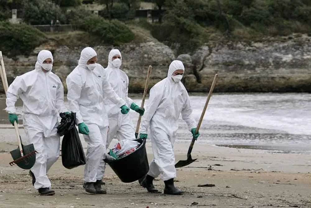 Anggota bomba memakai sut perlindungan ketika mengumpul sampel pencemaran di pantai Vaux-sur-Mer berhampiran Royan, barat daya Perancis.