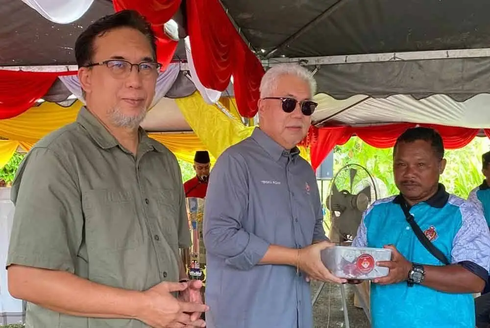 Tengku Mohamad Rizam (tengah) menyampaikan sumbangan daging korban kepada masyarakat Orang Asli.