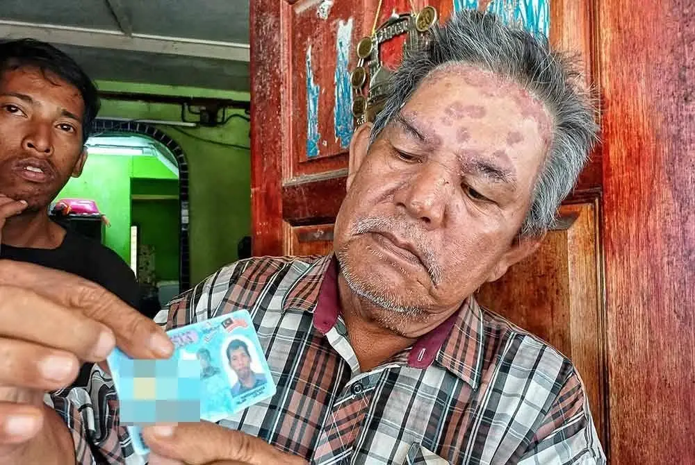 Syed Mohd Ali Hanafiah menunjukkan gambar anak sulungnya, Syed Alwi ketika ditemui di rumahnya di Tanah Puteh pada Khamis. - FOTO: SINAR HARIAN