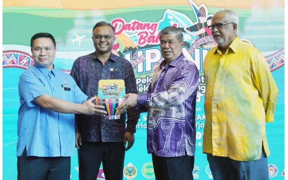 Mohamad bersama Isham dan Mahfuz menyerahkan replika HPPNK 2025 kepada Norsih pada HPPNK Tahun 2025.