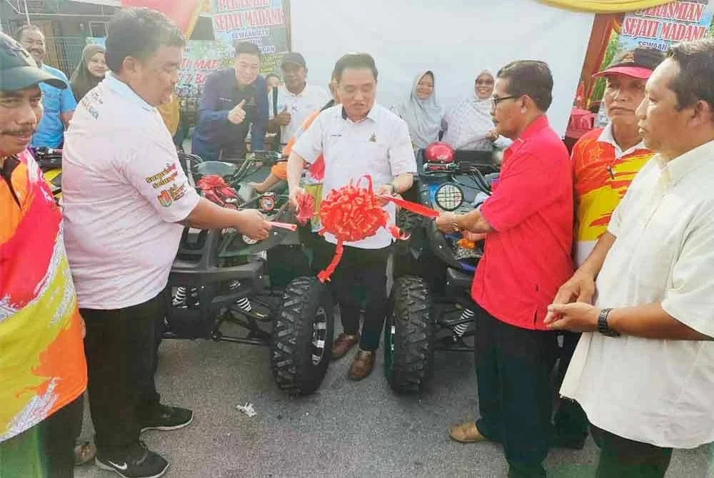 Suee Lim (tengah) memotong reben sebagai simbolik perasmian Program Sejati Madani Sewaan ATV Pelancongan di Balai JPKK Parit 7 Baroh, Sabak Bernam pada Sabtu.